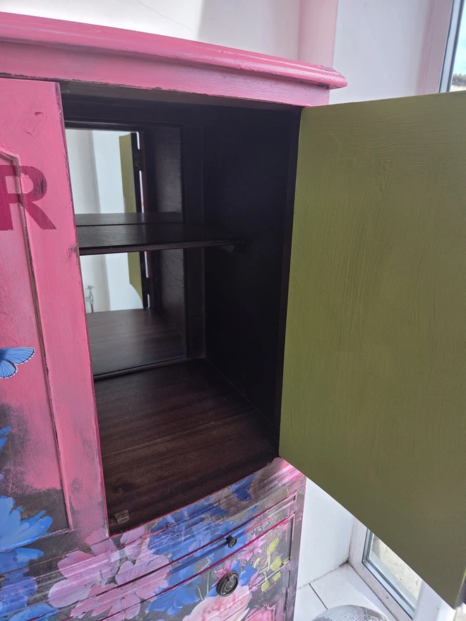 Interior of painted vintage wooden cabinet with pink, blue and floral decoration