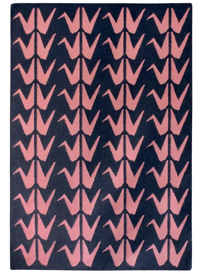 Crane Flatweave Rug, a colourful rug sitting on a plain surface. 