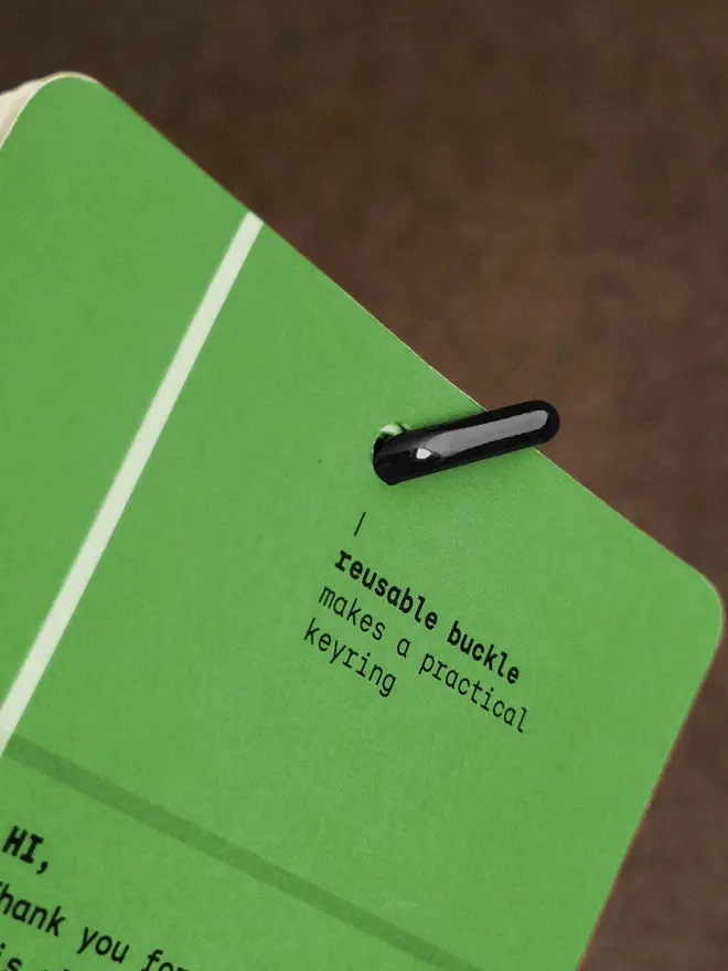 Closeup of green Squared: 2027 Monthly Wall Calendar, showing buckle clip binding