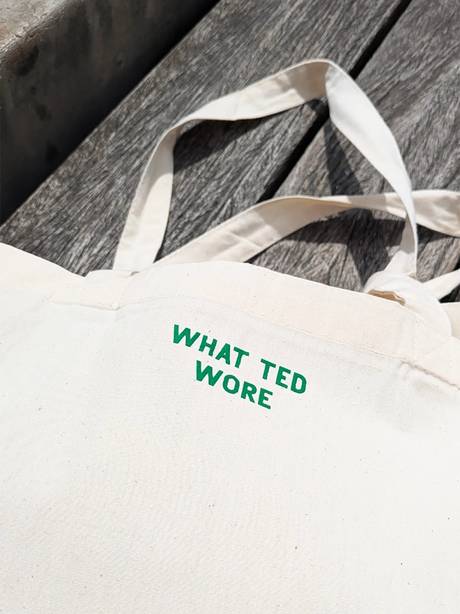 A natural coloured tote bag with green What Ted Wore branding