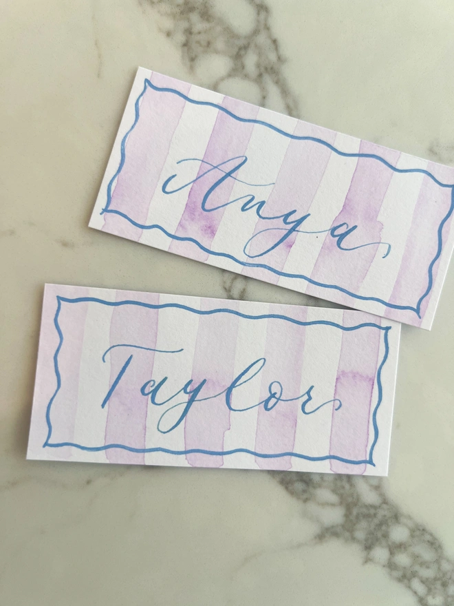Personalised calligraphy event place cards, purple striped coloured place cards with blue calligraphy name
