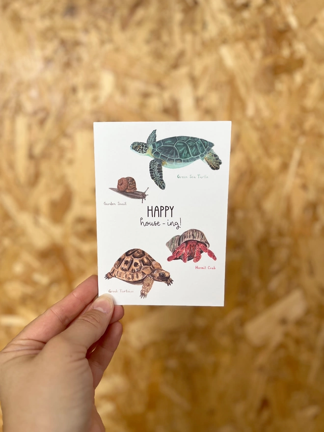 a greetings card featuring four animals who carry their own home with the phrase “happy house-ing”