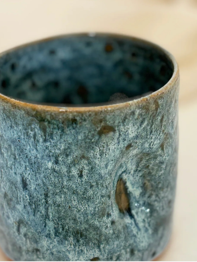 Pinch Mug. A close up of a Blue Regular Pinch Mug against a cream background.