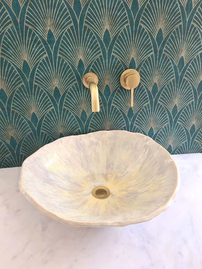 Ceramic bathroom basin, hand-crafted basin, sink, wc, bathroom, ensuite, modern bathroom, photographed against colourful green art deco wallpaper with gold taps