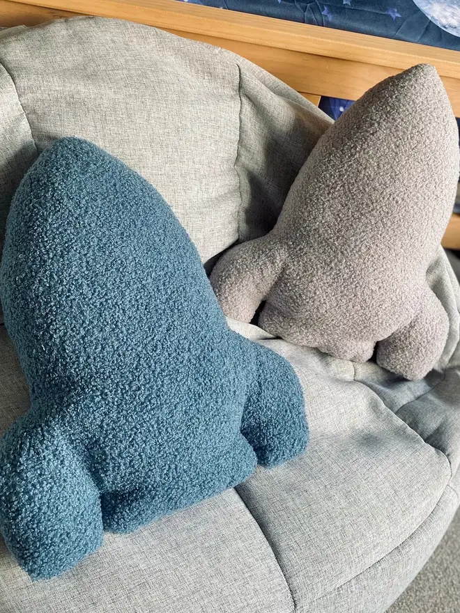 boucle rocket pillow. blue and grey rocket cushions on a bed.