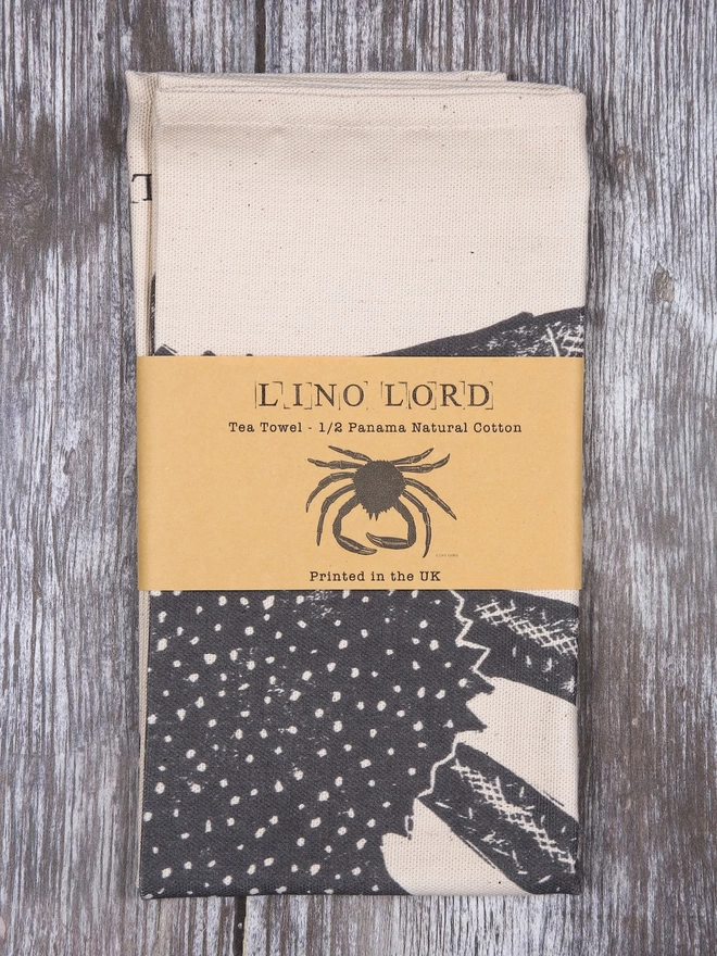 Picture of a folded tea towel with an image of a spider crab, taken from an original lino print