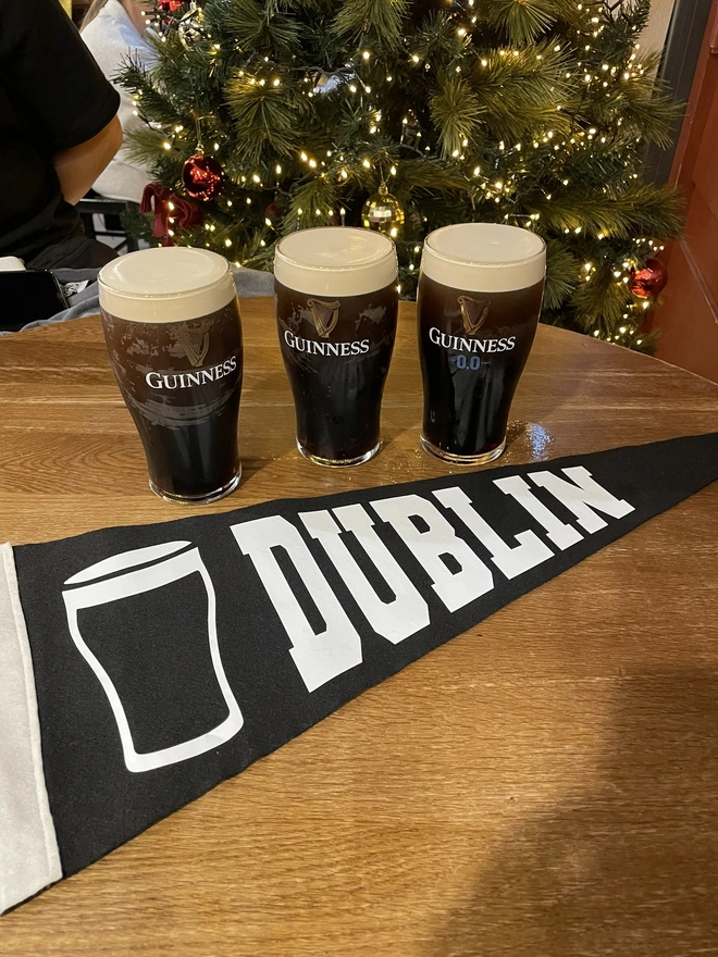 a felt pennant flag black and white, it has the word DUBLIN written in the varsity style and a pint of Guiness next to it