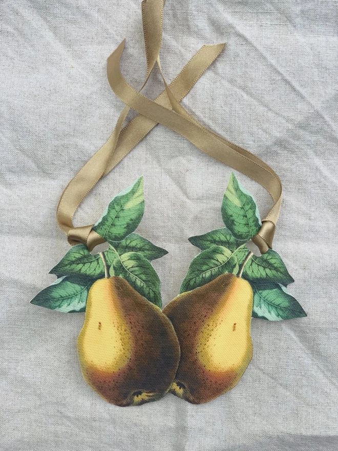 A pair of napkin ties in the shape of a vintage botanical pear