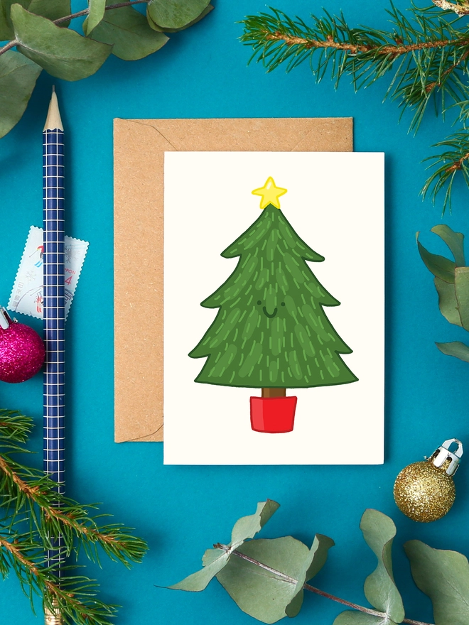 Illustration of a happy Christmas tree with a yellow star, on a mini card with kraft envelope