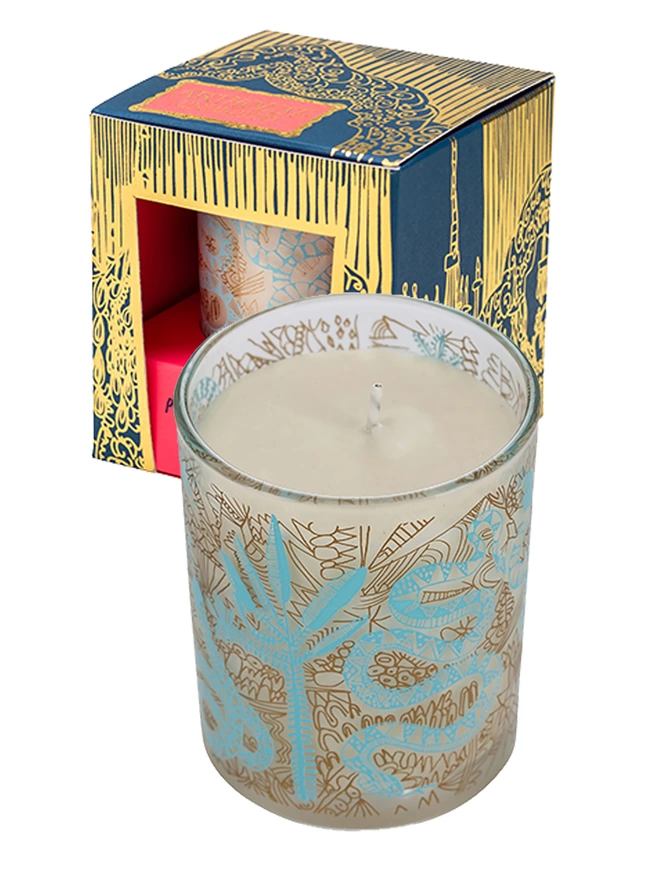 enchanted, amber & tonka bean charity candle in a reusable glass next to arthouse unlimited box