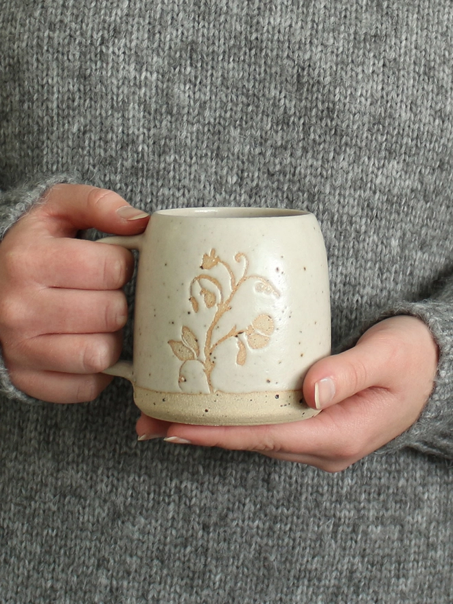 Hands holding sweet pea mug