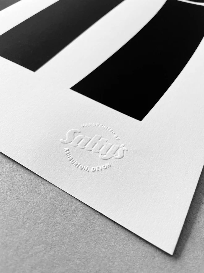 Close up of bottom right corner of a screen print sat on a grey background - showing detail of an embossed stamp saying Salty’s