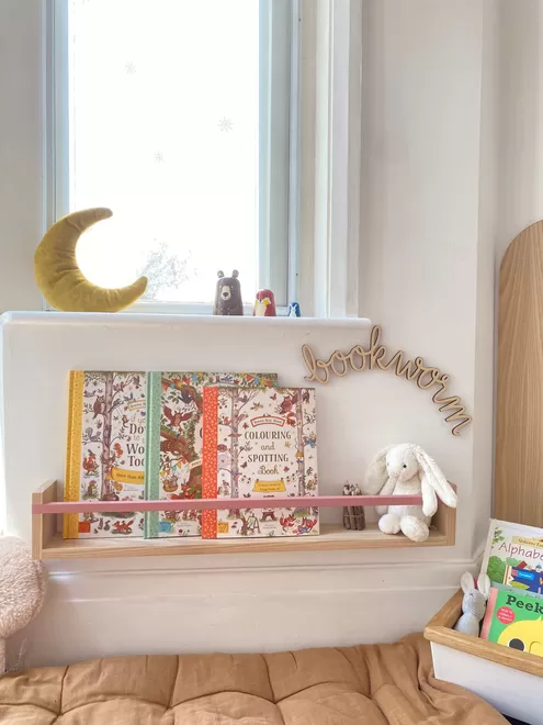A large handmade wooden bookshelf in a cosy kids reading corner 
