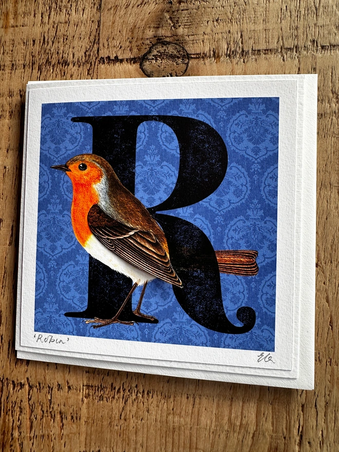 Handmade card with a Robin on a blue background with a big letter R.