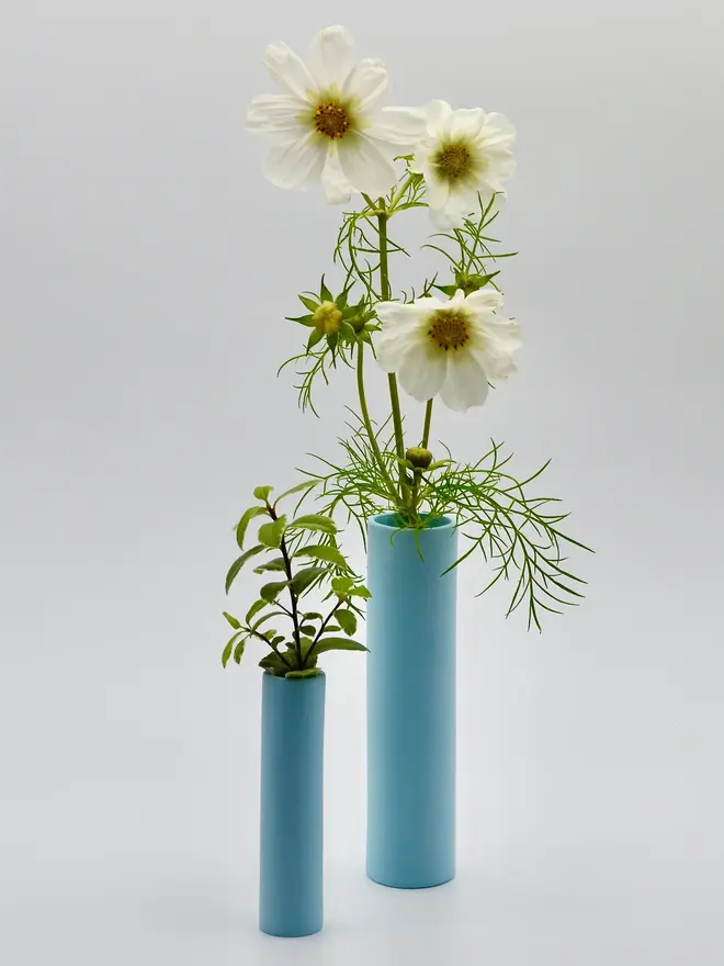 2 blue stem vases with flowers