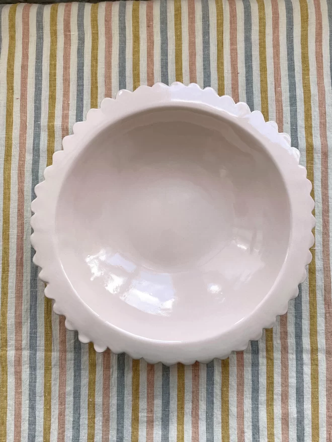 top down view of large pale pink serving bowl with flat scalloped rim