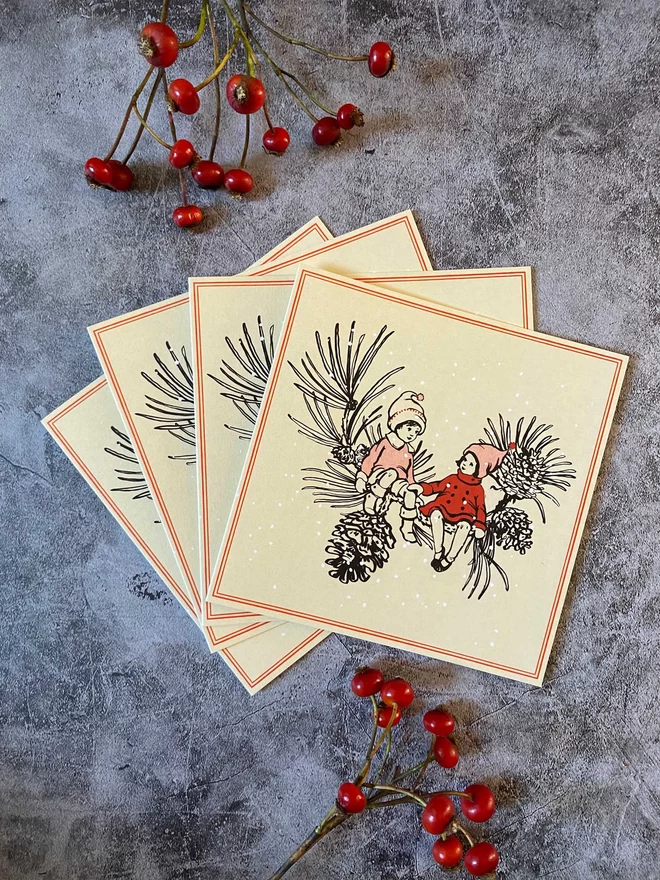 4 cream Christmas cards featuring 2 vintage style children wearing a red coat and oink bobble hat