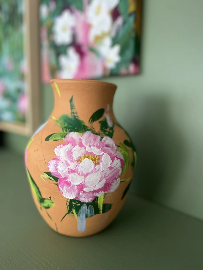 close up photo, hand thrown terracotta dried flower vase hand painted pink peony blooms