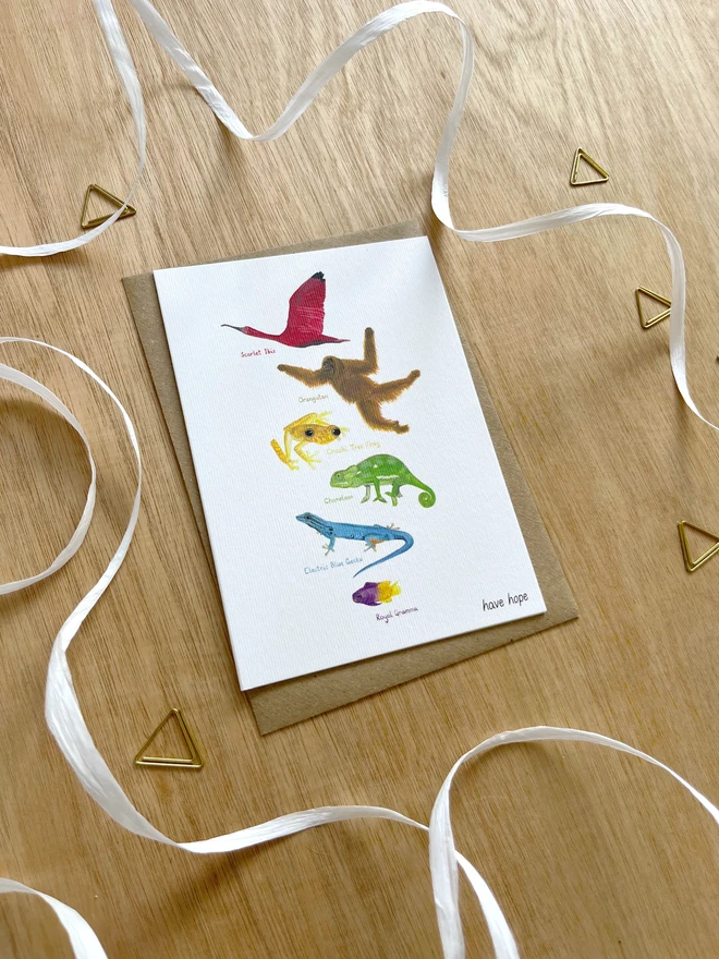 a greetings card featuring illustrations of animals in colours making up the rainbow with the text “have hope”