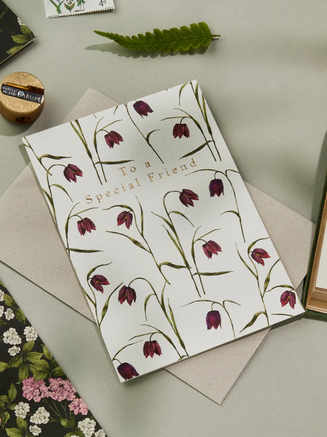 'to a special friend' illustrated floral card. a white floral card photographed against a plain background.