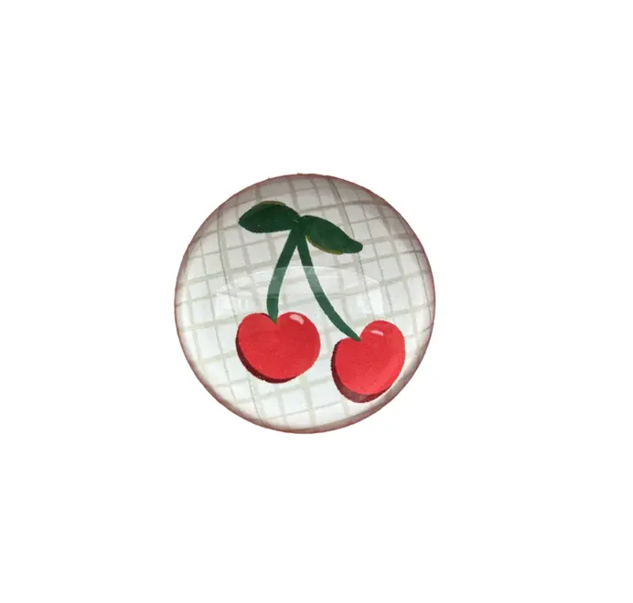 Round cherries glass paperweight on a white background. 