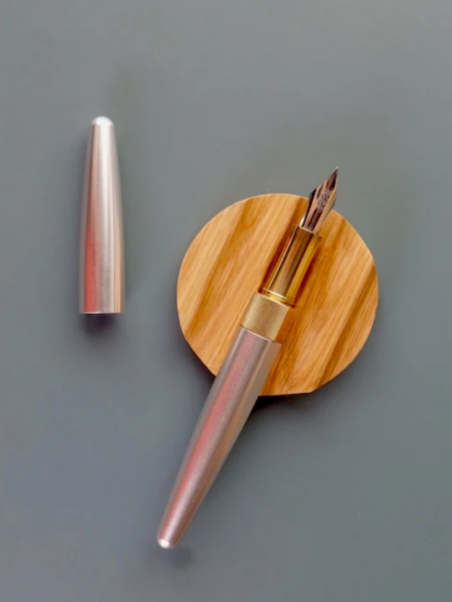 Tani Wooden Pen Rest. An Oak pen rest being shown in use with an open pen resting on top.