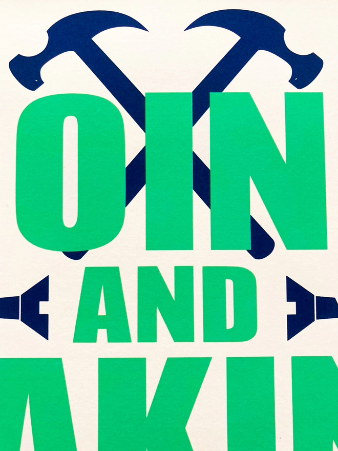 Detail from a green and blue typographic print. The Corita Kent quote reads "Doing and making are acts f hope." Navy blue tools are placed around the green text.