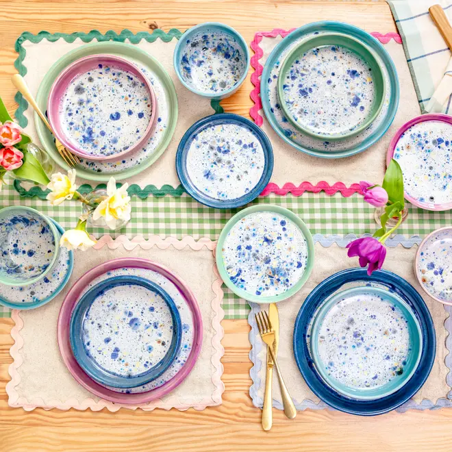 Shoreline Dinner Plate, a table setting filled with colourful plates, napkins and utensils. 