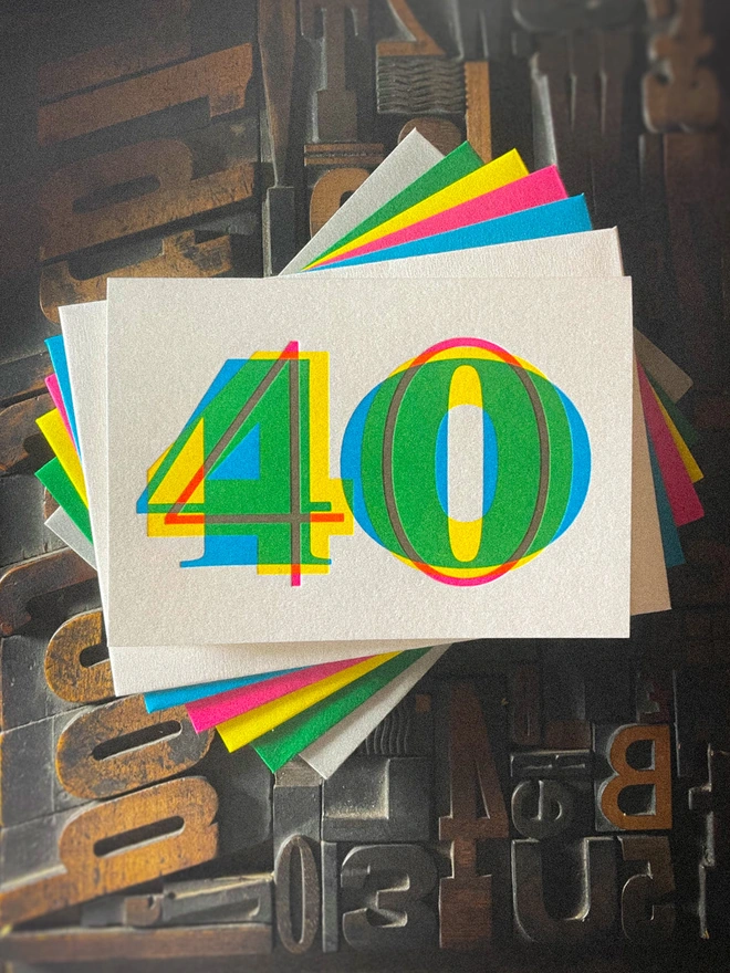 Contemporary handmade letterpress 40th birthday card featuring a bold oversized "50" in a vibrant typographic design. Printed using overlapping cyan, magenta and yellow inks to create striking secondary colours with a deep tactile letterpress impression. Individually hand printed on premium 350gsm GF Smith Colorplan card and paired with a high-quality 135gsm GF Smith Colorplan envelope in a complementary colour. Produced on a beautifully restored 1915 Arab Crown Folio press.