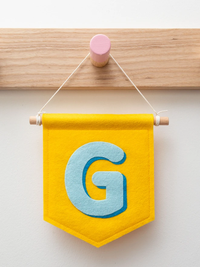 yellow banner with the letter G in blue felt