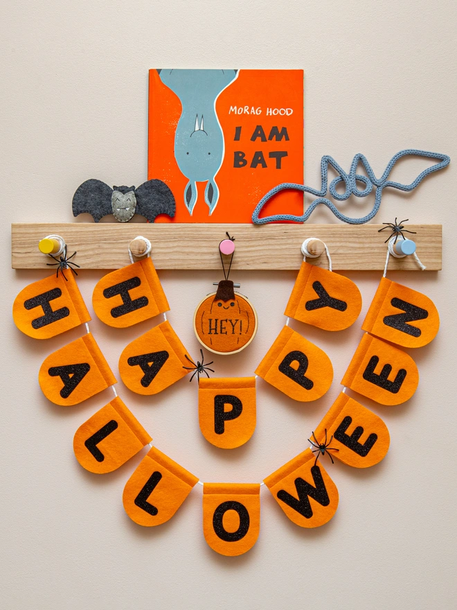 orange, felt halloween scalloped bunting with text that reads "HAPPY HALLOWEEN" written in black glitter