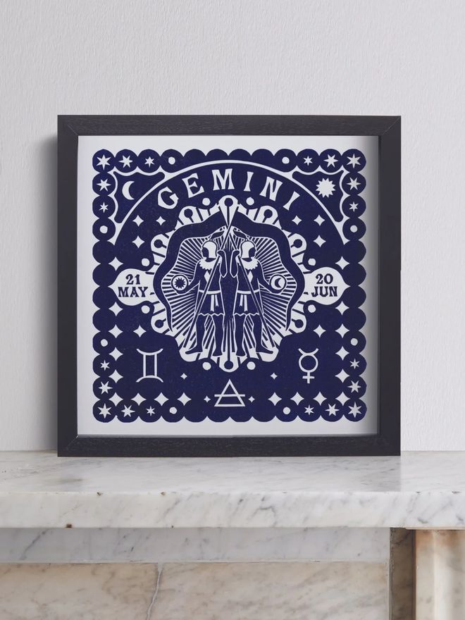 gemini zodiac linocut. twins and zodiac symbols linocut and printed on a blue background.