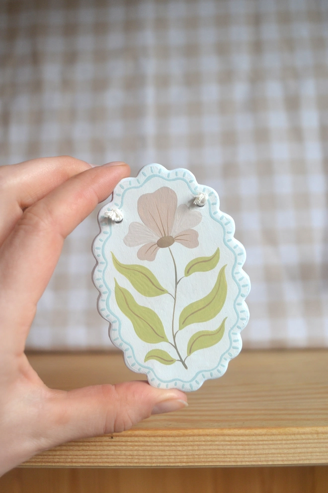 hanging ceramic ornament with blue border and pink an green flower