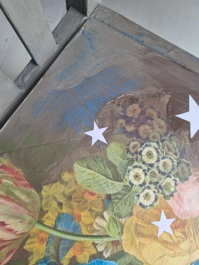 Vintage painted dressing table and chair. Painted in coffee grey and decorated using layered antique florals with yellow and blue accents and finished with hand-cut white paper stars. Text reads in blue 'think happy thoughts'. Heavily distressed finish.