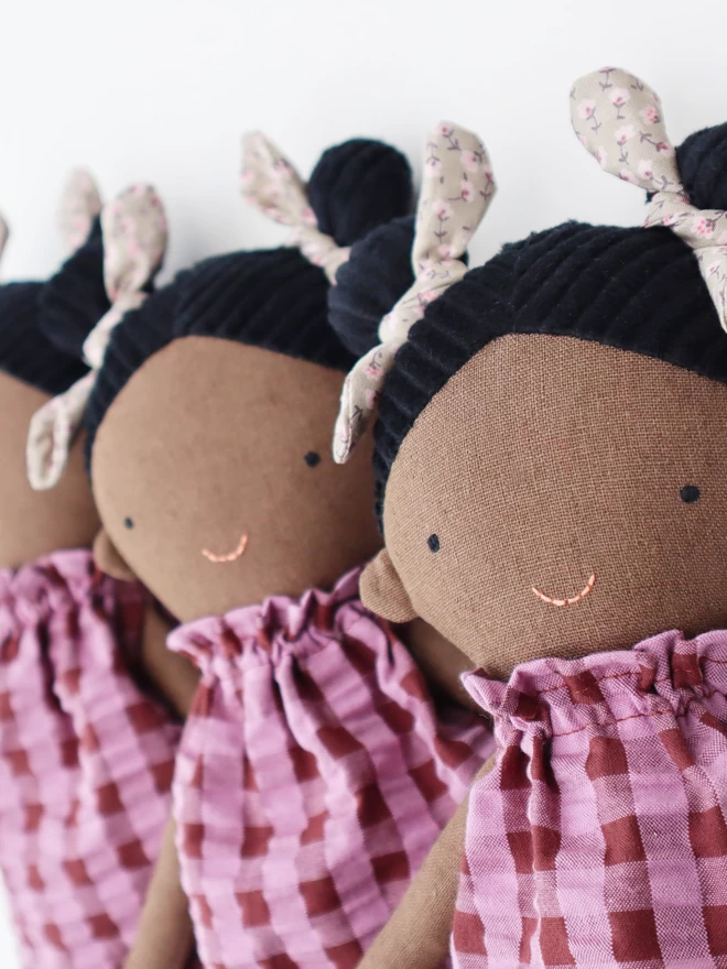 dark skin textile doll with pink gingham dress