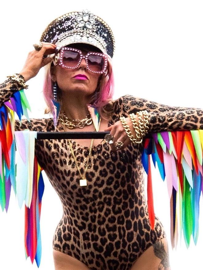 A Leopard Print Leotard with gold sparkle, made with Econyl. Long sleeves and Rainbow feather effect wings 