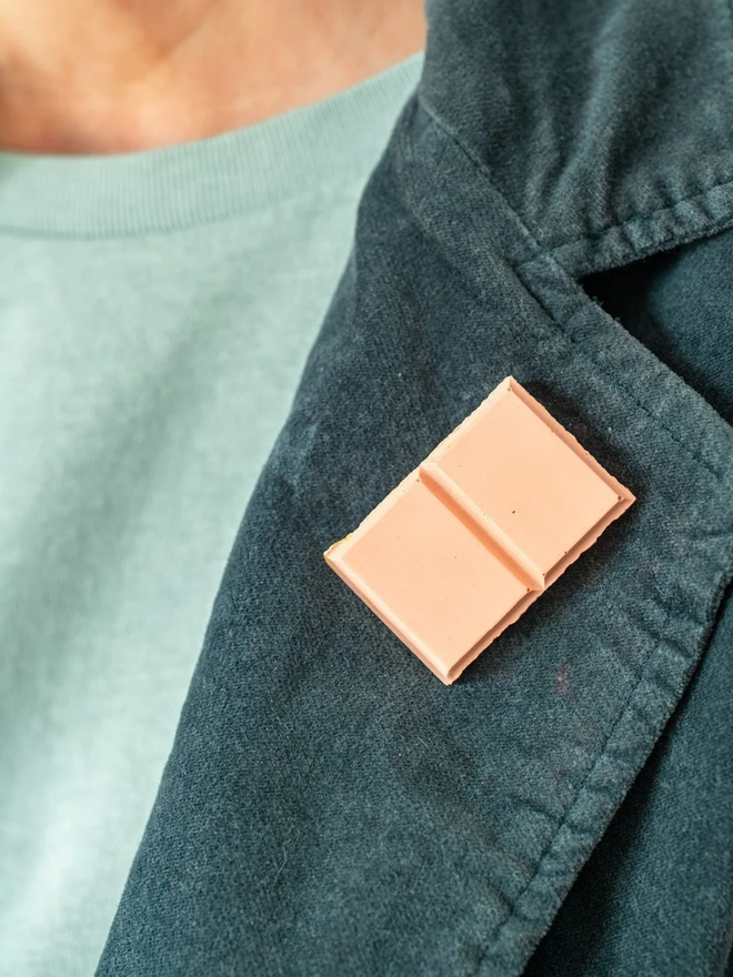 chocolate pin badges. a ruby pink chocolate badge on a coat lapel.