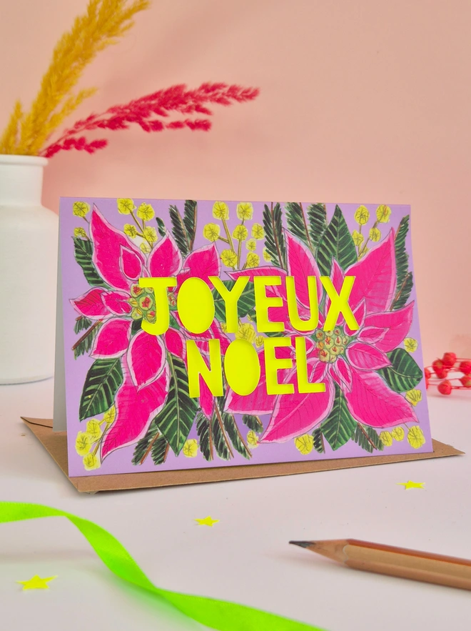 Pink poinsettia Christmas Card with paper cut Joyeux Noel text and neon yellow backing paper 