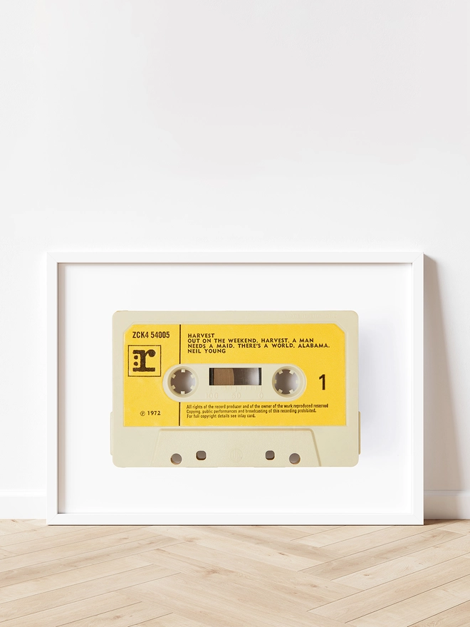 neil young harvest cassette tape print. framed print propped up against white wall and wooden floor.