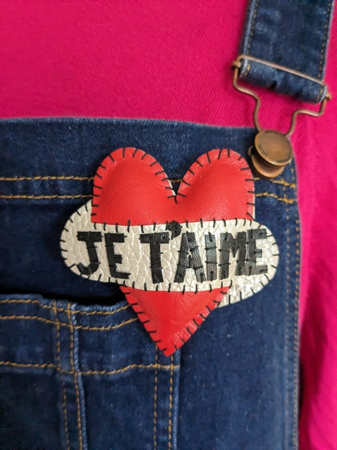 Red Heart Brooch seen on denim dungarees.