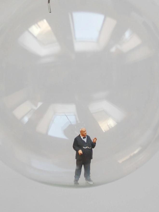 Miniature figure of Winston Churchill in a glass Christmas bauble - close up 