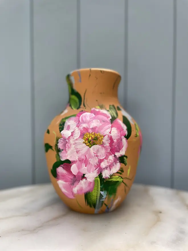 Unique hand-painted terracotta pot featuring pink peony on a terracotta background