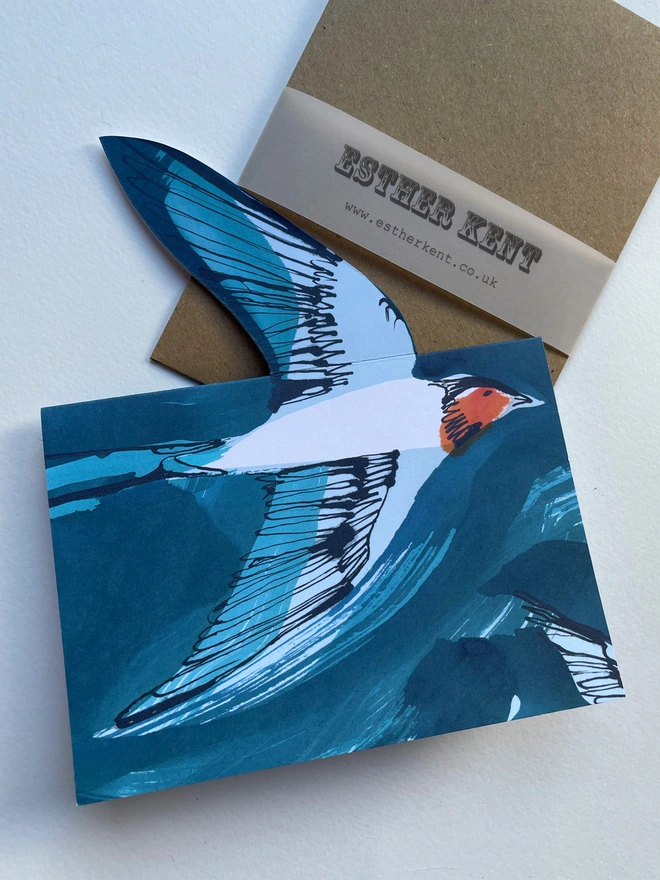 Esther Kent illustrated greeting card showing inky blue swallow illustration on a teal background. The swallow's wing pops u.