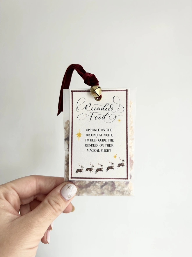 Reindeer food made from oats and dried petals in glassine bag with red velvet ribbon and gold bell and poem label