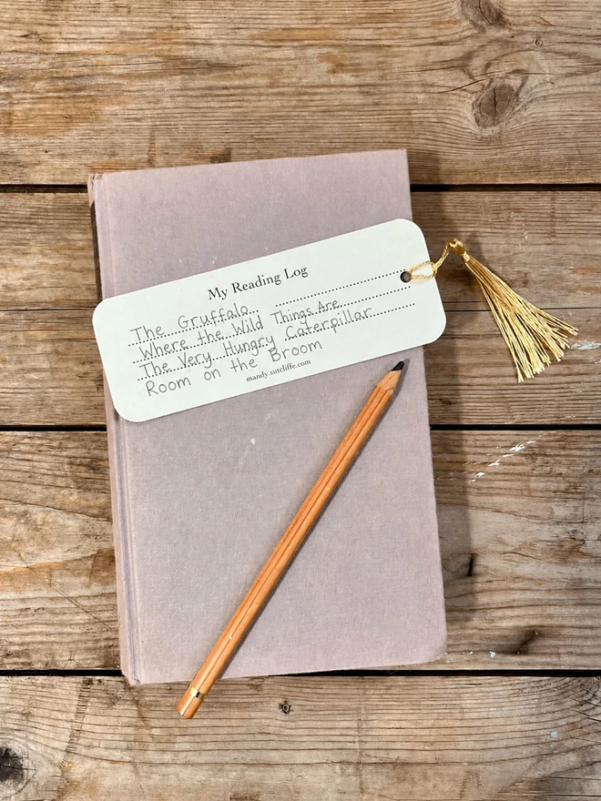 a photograph of the back on a book mark showing a reading log filled in with a childs writting of recent books read