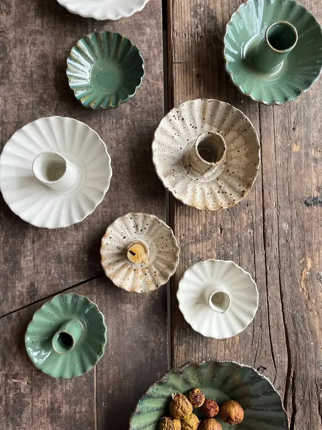 Handmade Natural Speckled Ceramic Candlestick Holder, a group of candlestick holders sitting on a wooden surface. They are accompanied by a bowl of food. 