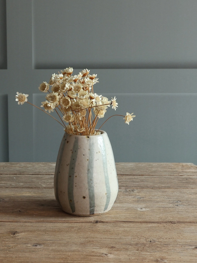 Handmade Ceramic Stoneware Small Vase in Blue and White Stripe filled with dried flowers sat on a wooden surface