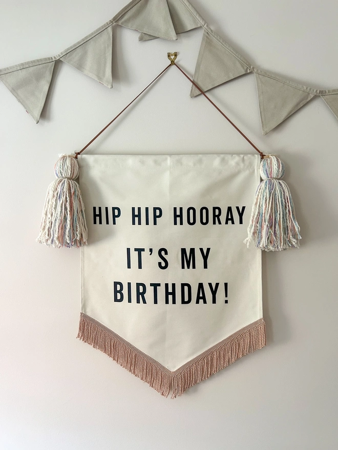 Large handmade fabric birthday banner for birthday celebrations and parties with pastel tassels and rose gold trim 