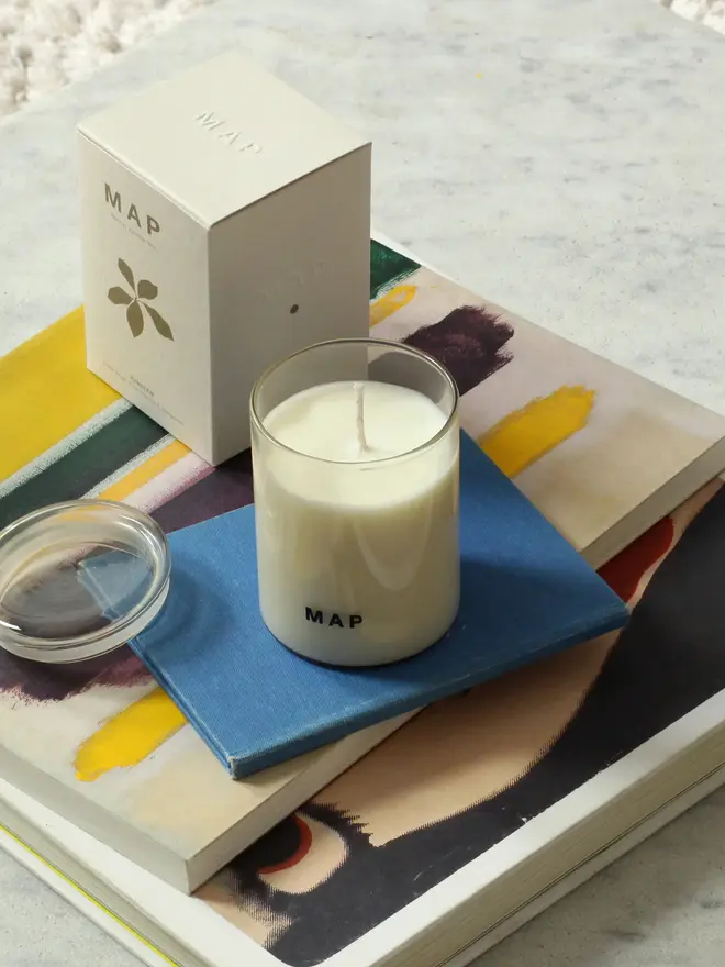 sunbeam clary sage and bergamot soy candle. candle and plastic free box photographed on top of coffee table books.