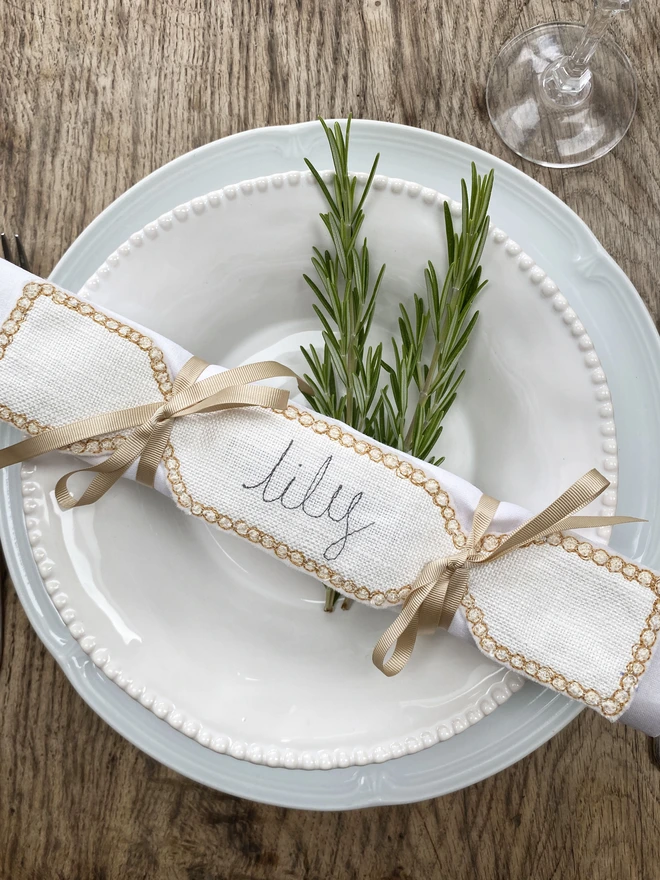 Fabric cracker napkin decoration on a plate with rosemary